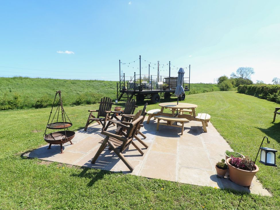 A garden with a seating area and fire pit at Sweet Caroline Shepherd’s Hut Low Marnham near Sutton-On-Trent