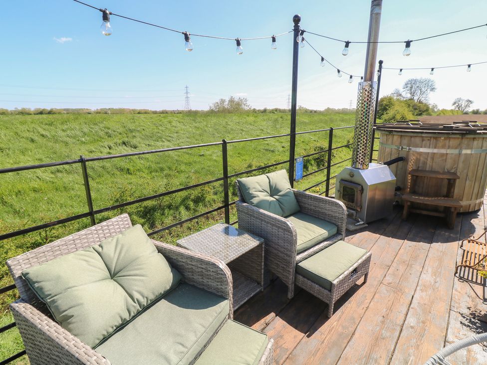 An outdoor patio with seating and a hot tub at Sweet Caroline Shepherd’s Hut in Low Marnham near Sutton-On-Trent