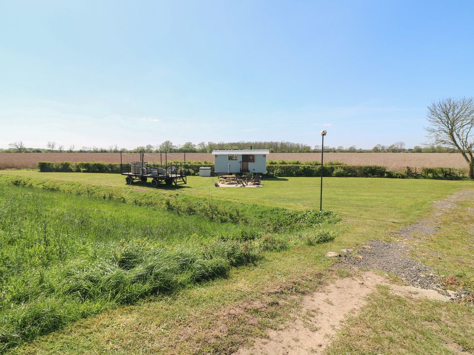 A hut with decking and a lawn at Sweet Caroline Shepherd’s Hut Low Marnham near Sutton-On-Trent