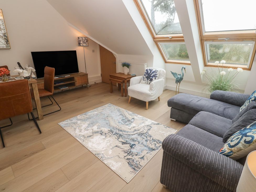 A living room with a television, sofa, and dining table at Upper Deck in Truro