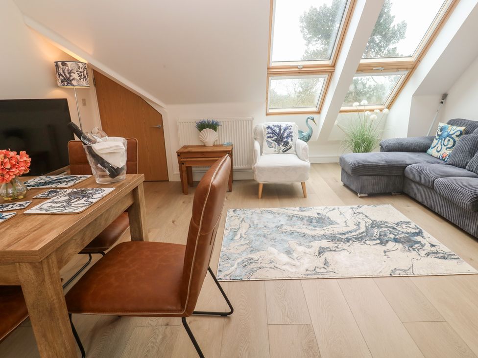A living room with a sofa and dining table at Upper Deck in Truro