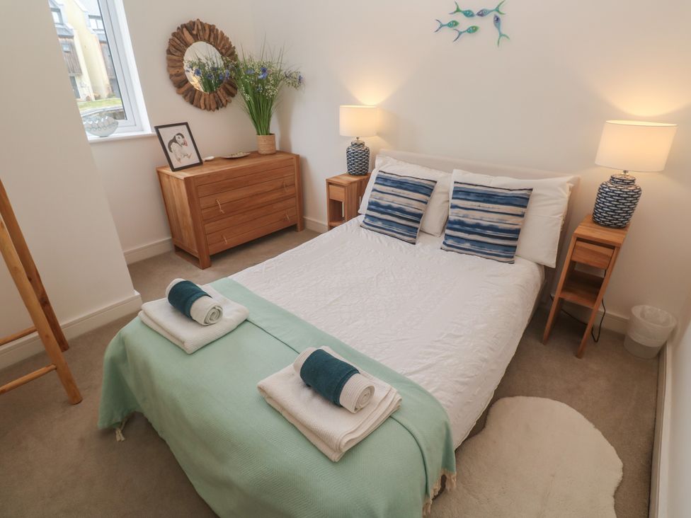 A bedroom with a bed and nightstands at Upper Deck in Truro