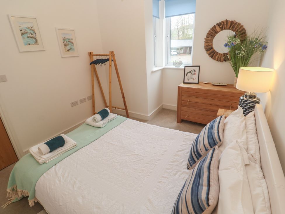 A bedroom with a bed and dresser at Upper Deck in Truro
