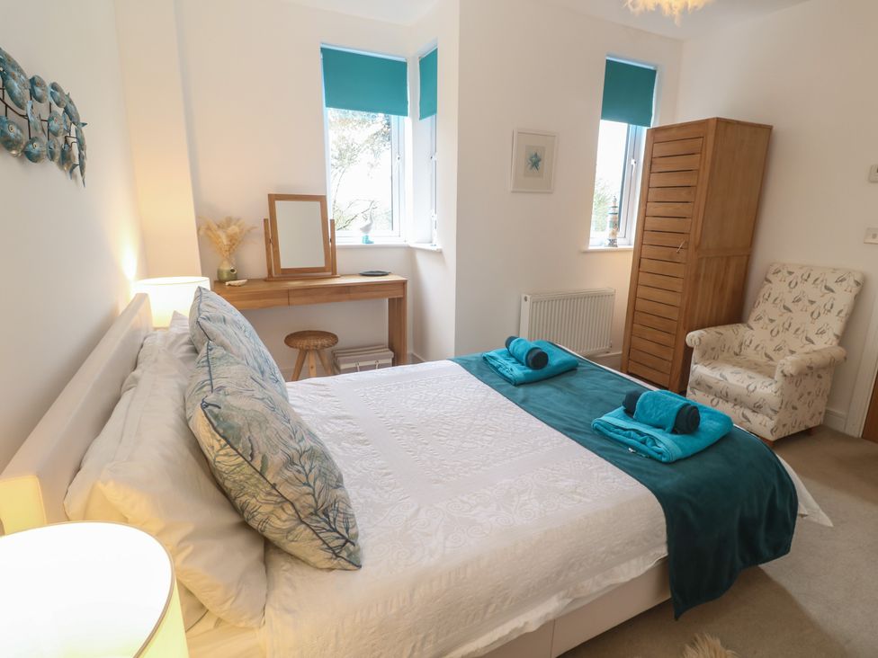 A bedroom with a bed and dressing table at Upper Deck in Truro