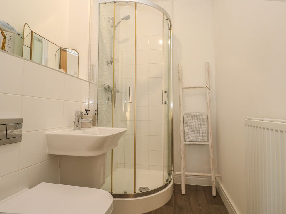A bathroom with a shower, sink, and toilet at Upper Deck in Truro
