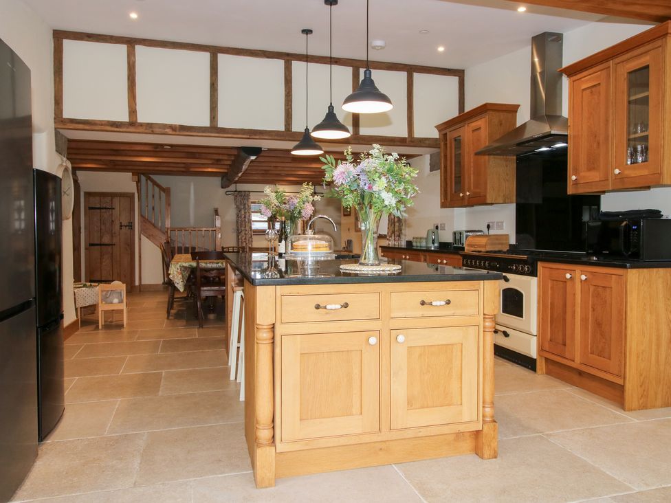 A kitchen with wooden cabinets and an island at Grove Farm in Cardington near Church Stretton
