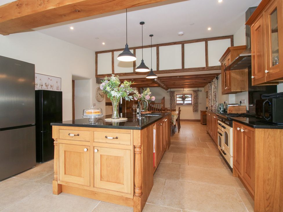 A kitchen with an island and refrigerator at Grove Farm in Cardington near Church Stretton