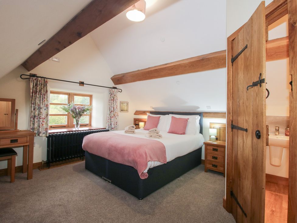 A bedroom with a bed and windows at Grove Farm in Cardington near Church Stretton