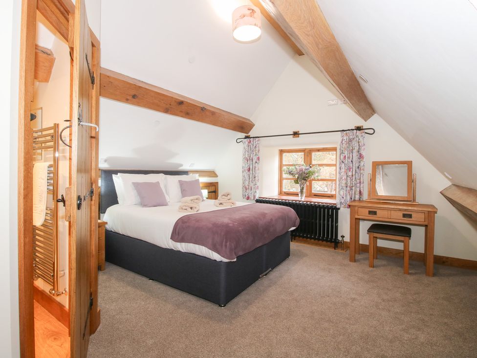 A bedroom with a bed and a mirror at Grove Farm in Cardington near Church Stretton