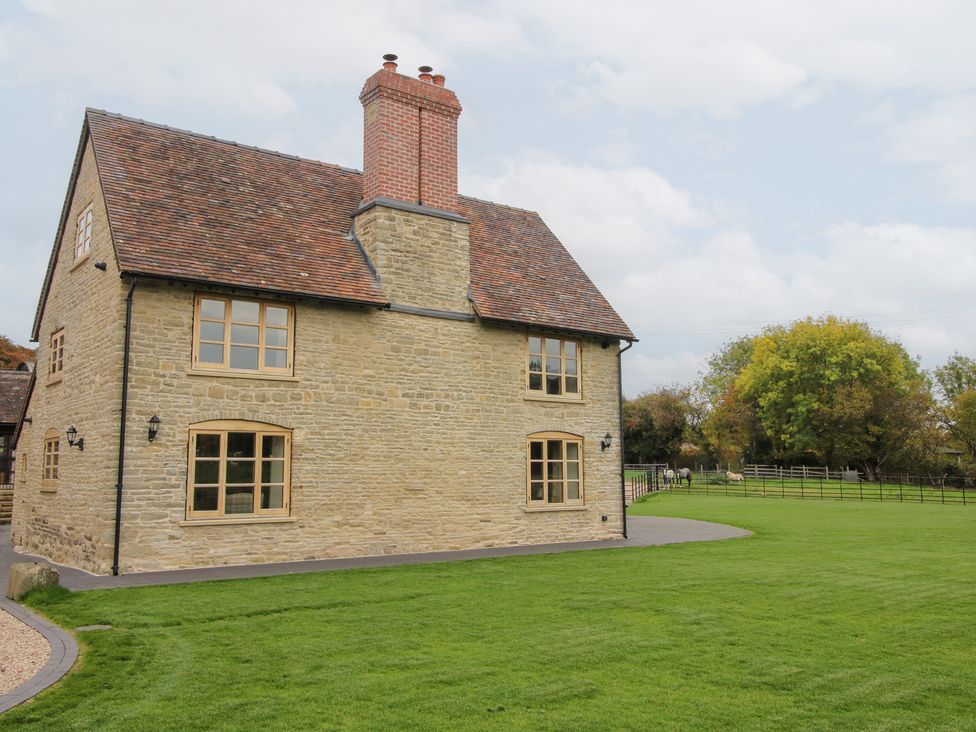 A stone house with windows and a chimney at Grove Farm in Cardington near Church Stretton