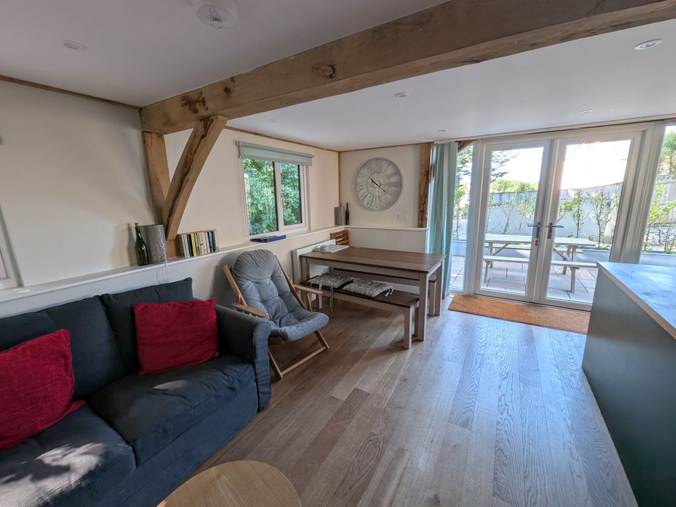 A living room with a sofa and a dining table at Roman Lodge in Osmington