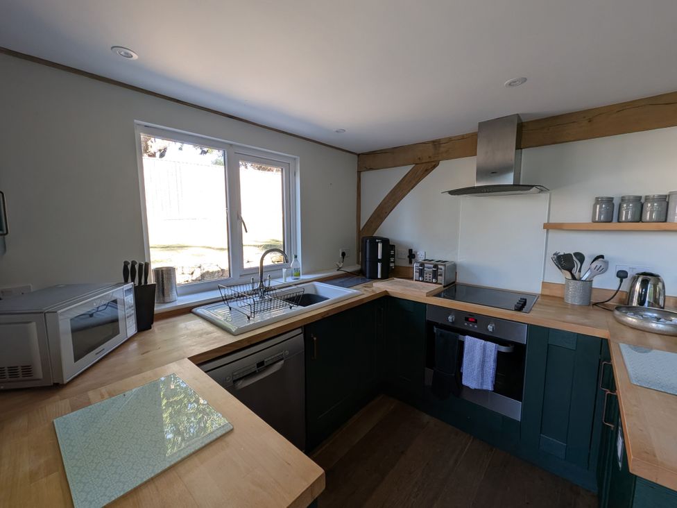 A kitchen with sink, oven, and appliances at Roman Lodge in Osmington