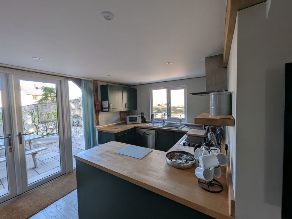 A kitchen with a sink and microwave at Roman Lodge in Osmington