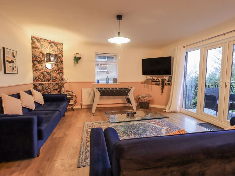 A living room with a foosball table and sofa at 8 Beechwood Close in Bowness-On-Windermere