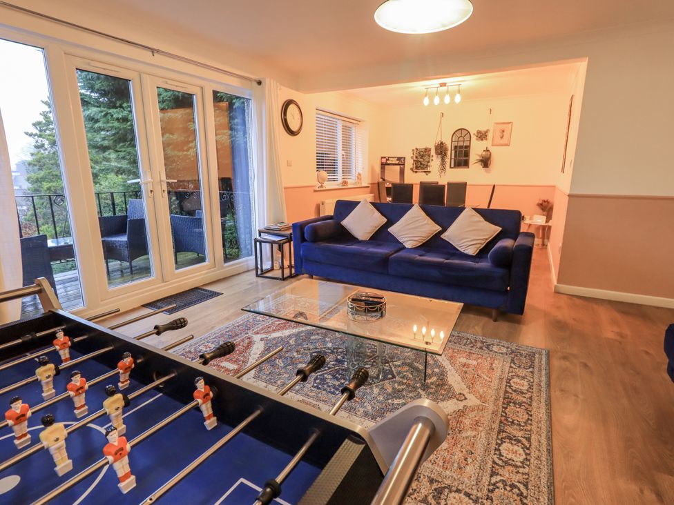 A living room with a sofa and foosball table at 8 Beechwood Close Bowness-On-Windermere