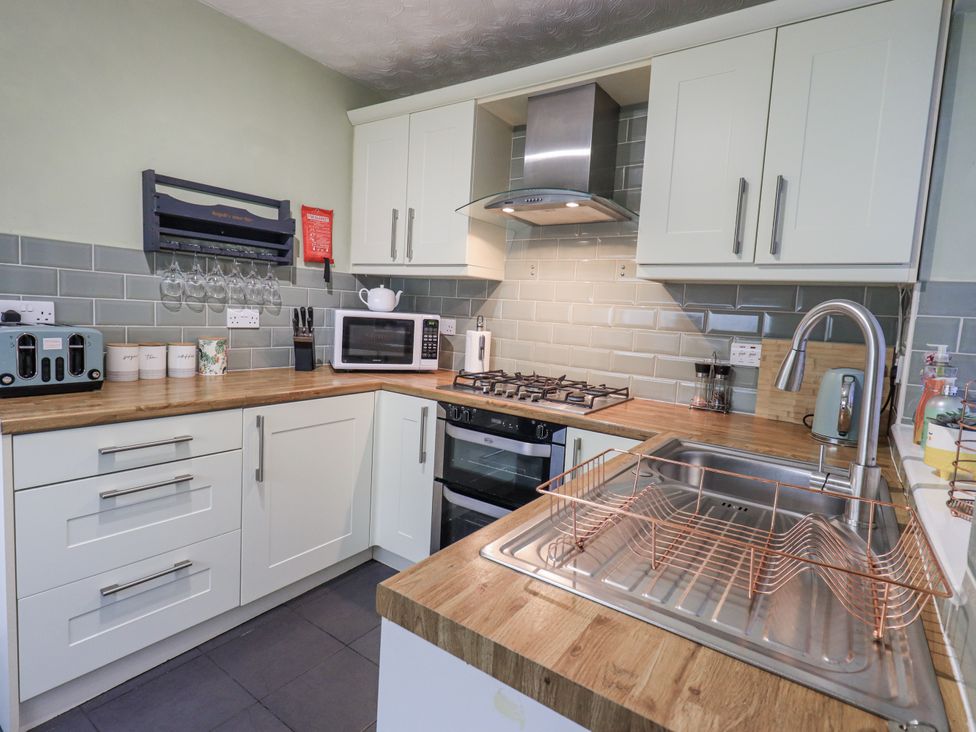 A kitchen with appliances and sink at 8 Beechwood Close Bowness-On-Windermere