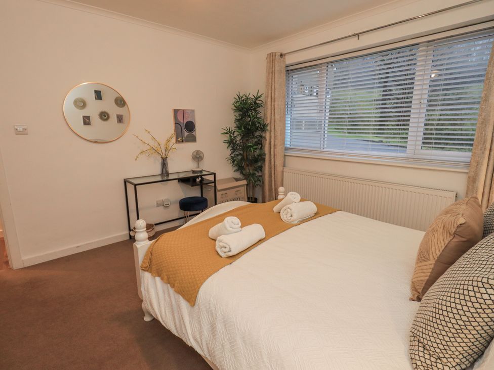 A bedroom with a bed and desk at 8 Beechwood Close in Bowness-On-Windermere