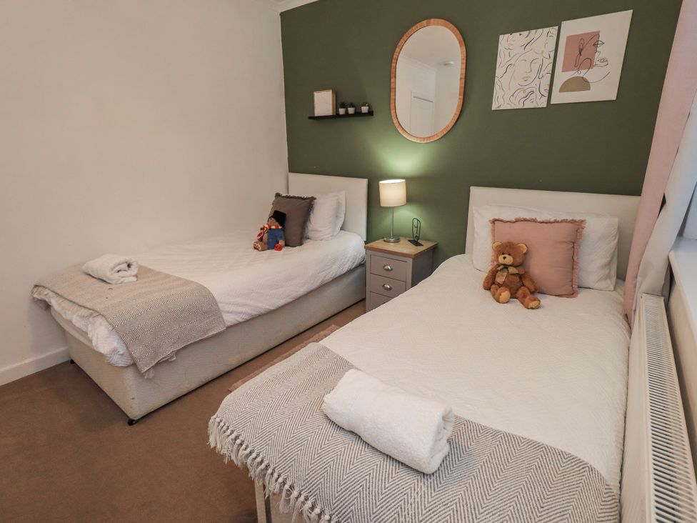 A bedroom with two single beds and a nightstand at 8 Beechwood Close Bowness-On-Windermere