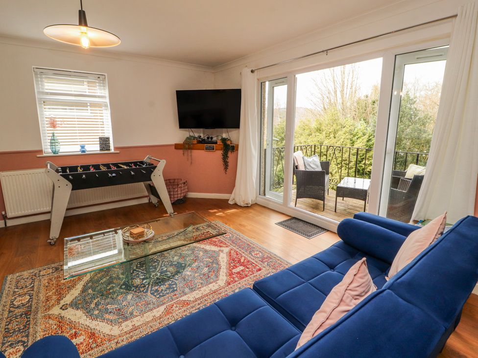 A living room with a foosball table and a television at Lake View in Bowness-On-Windermere