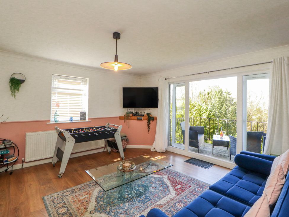A living room with a foosball table and television at Lake View in Bowness-On-Windermere