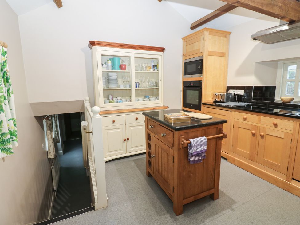 A kitchen with cabinets and an island at The Tithe Barn in Brignall near Barnard Castle