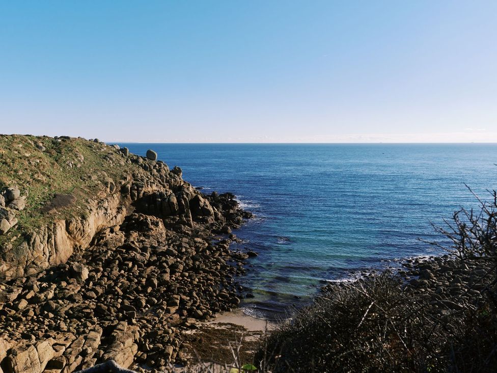 A coastal view with rocks and ocean at Three Chimneys in St. Levan near Porthgwarra