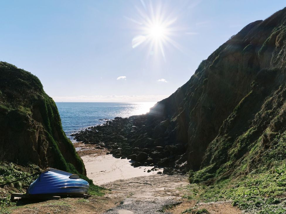 A beach scene with rocks and a boat at Higher Roskestal in St. Levan near Porthgwarra