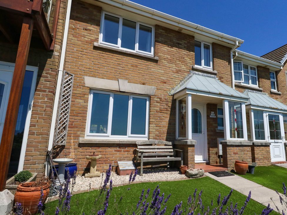 A house exterior with a front door and windows at Cove Cottage in Weymouth