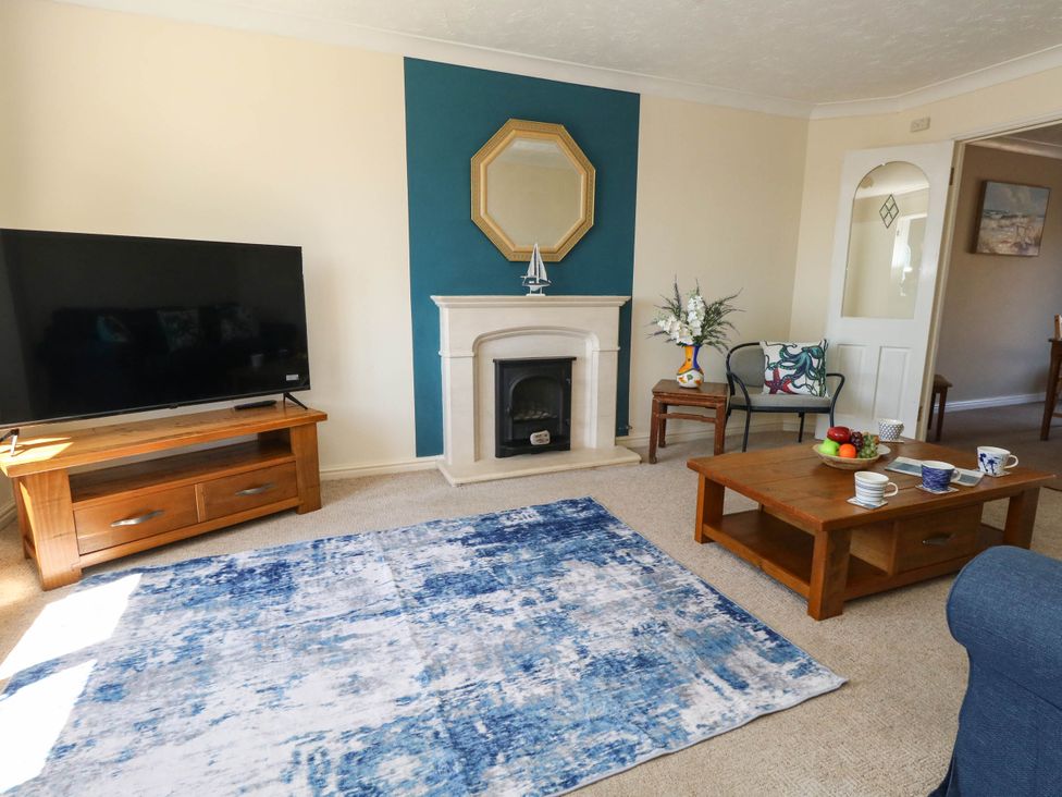 A living room with a television and coffee table at Cove Cottage in Weymouth