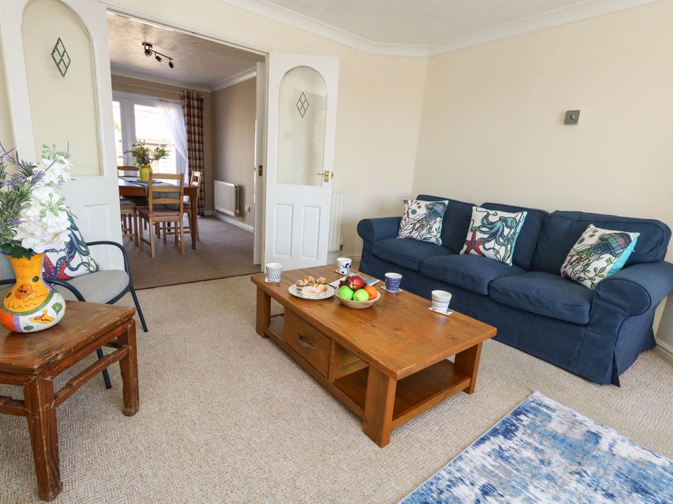 A living room with a sofa and coffee table at Cove Cottage in Weymouth