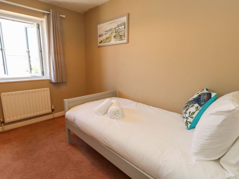 A bedroom with a bed and window at Cove Cottage in Weymouth