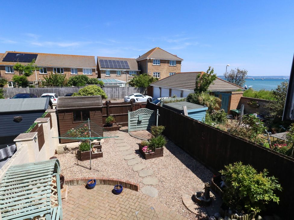 A garden with a shed, plants and pathway at Cove Cottage in Weymouth