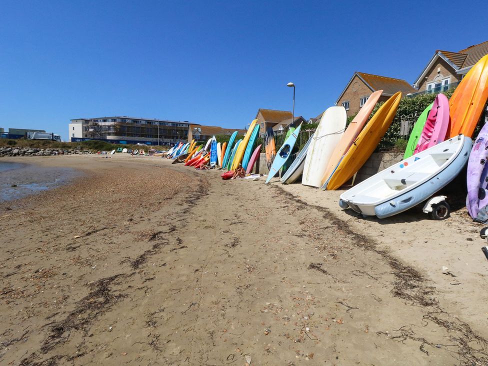 Surfboards and kayaks on a beach at Cove Cottage Weymouth