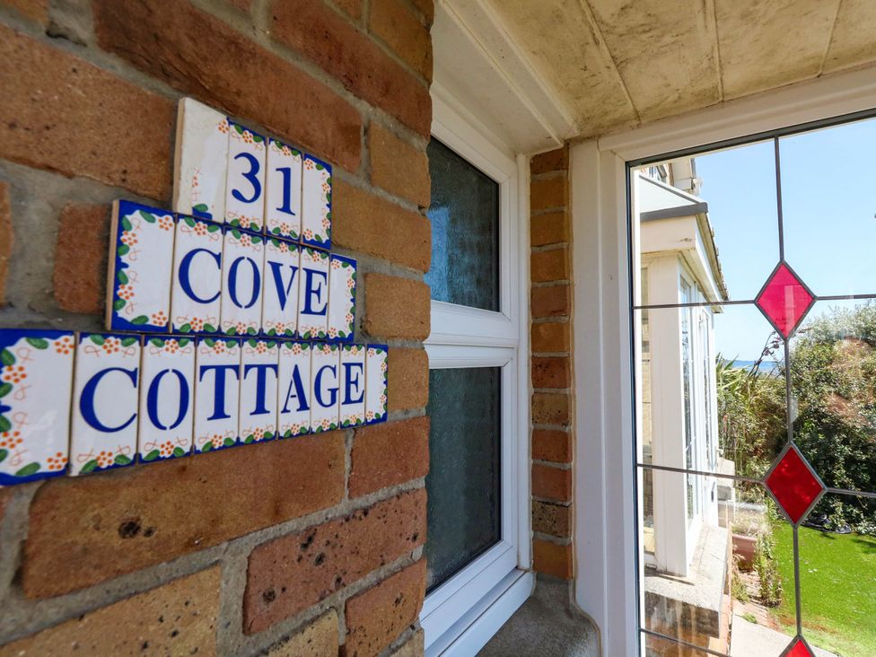 House number and cottage name on a brick wall at Cove Cottage in Weymouth