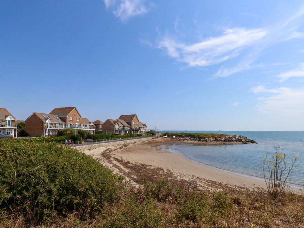 A beach with houses alongside at Cove Cottage in Weymouth