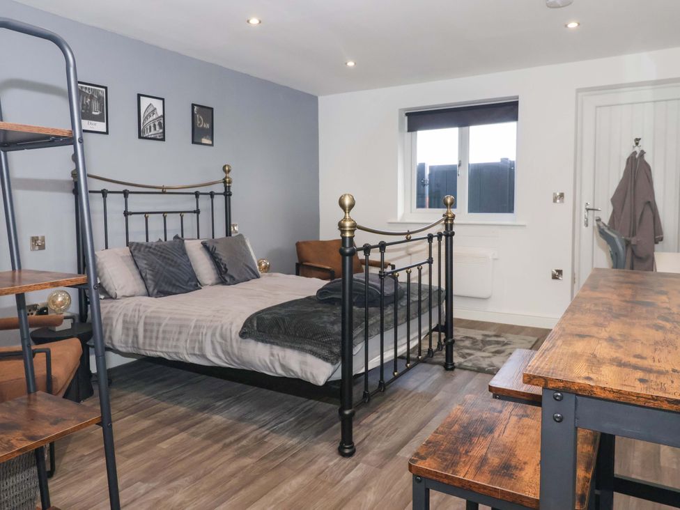 A bedroom with a bed and table at Chalet 2 in East Heslerton near Sherburn