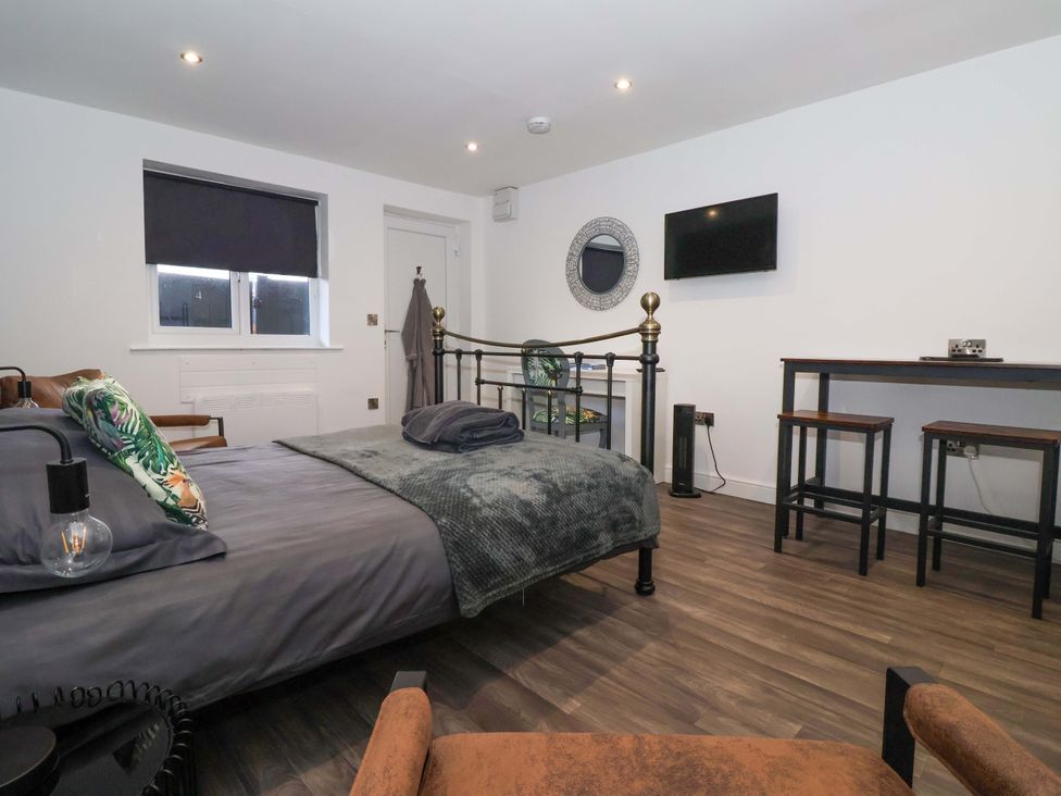 A bedroom with a bed, chair, and table at Chalet 4 East Heslerton near Sherburn