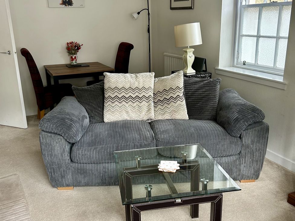 A living room with a sofa and dining area at The Toll House in Melrose