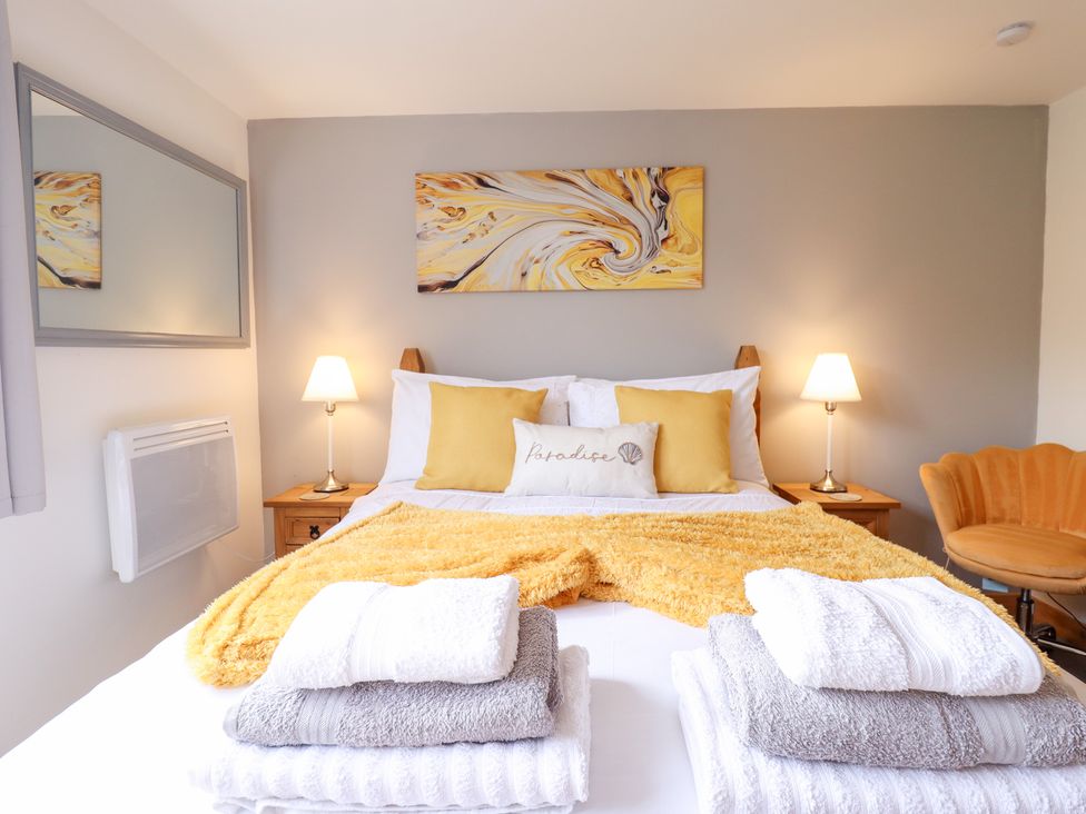 A bedroom with a bed and towels at Angel's Retreat in Huttoft