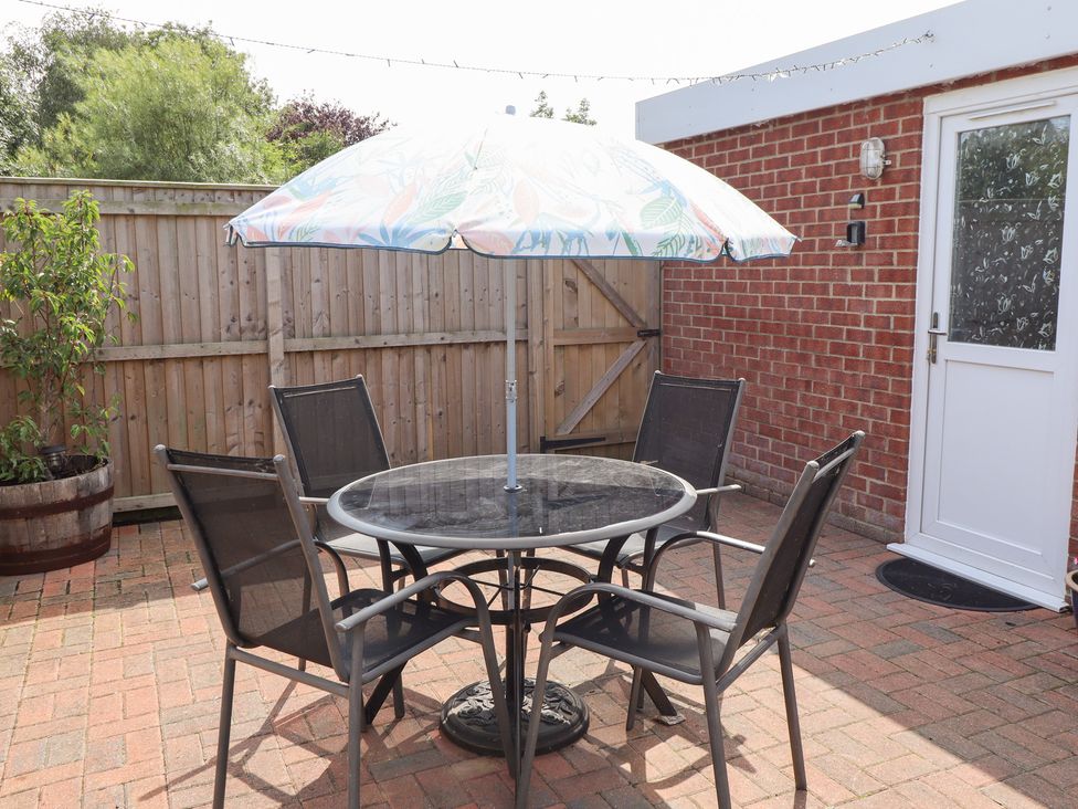 A garden with a table and chairs under an umbrella at Angel's Retreat in Huttoft