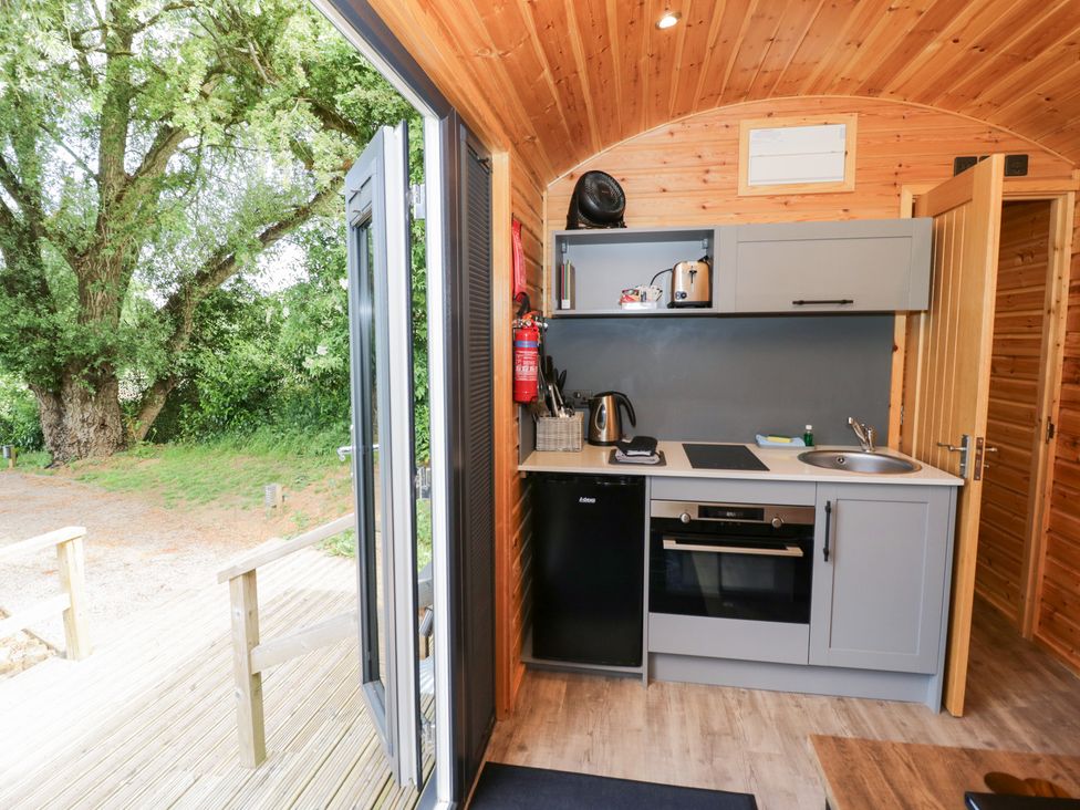 A kitchen with cabinets and appliances at The Shepherds Hut at Bridge Lake Farm & Fishery Chacombe