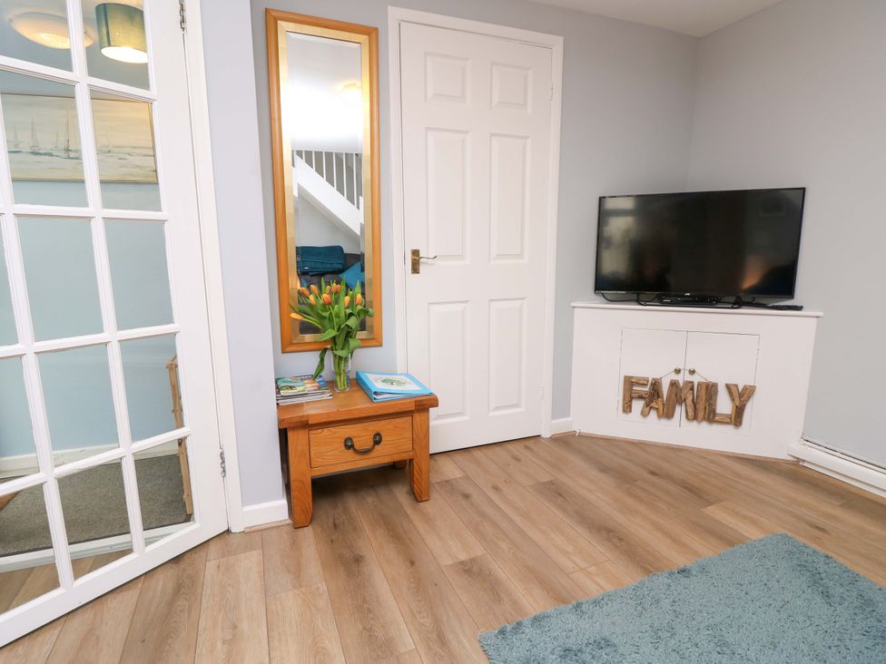 A living room with a mirror and a television at Willow Cottage in Ventnor