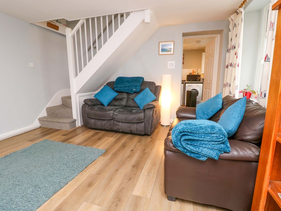 A living room with sofas and a staircase at Willow Cottage in Ventnor