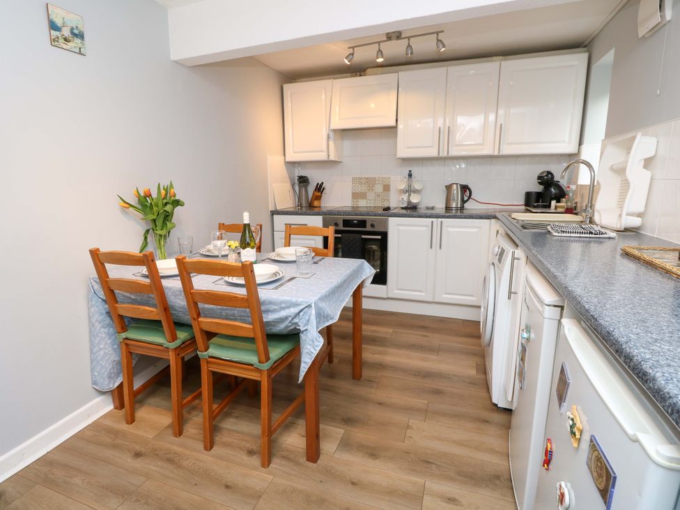 A kitchen with table and chairs at Willow Cottage in Ventnor