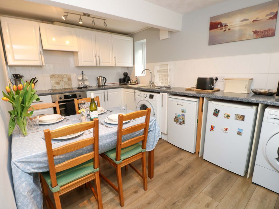 A kitchen with dining area and appliances at Willow Cottage in Ventnor