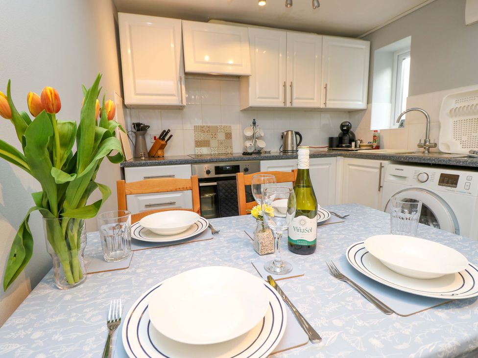 A kitchen with a dining table and chairs at Willow Cottage in Ventnor