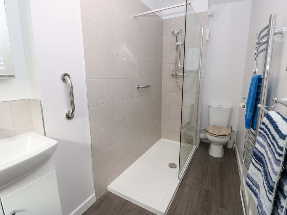 A bathroom with a shower, toilet, and sink at Willow Cottage in Ventnor