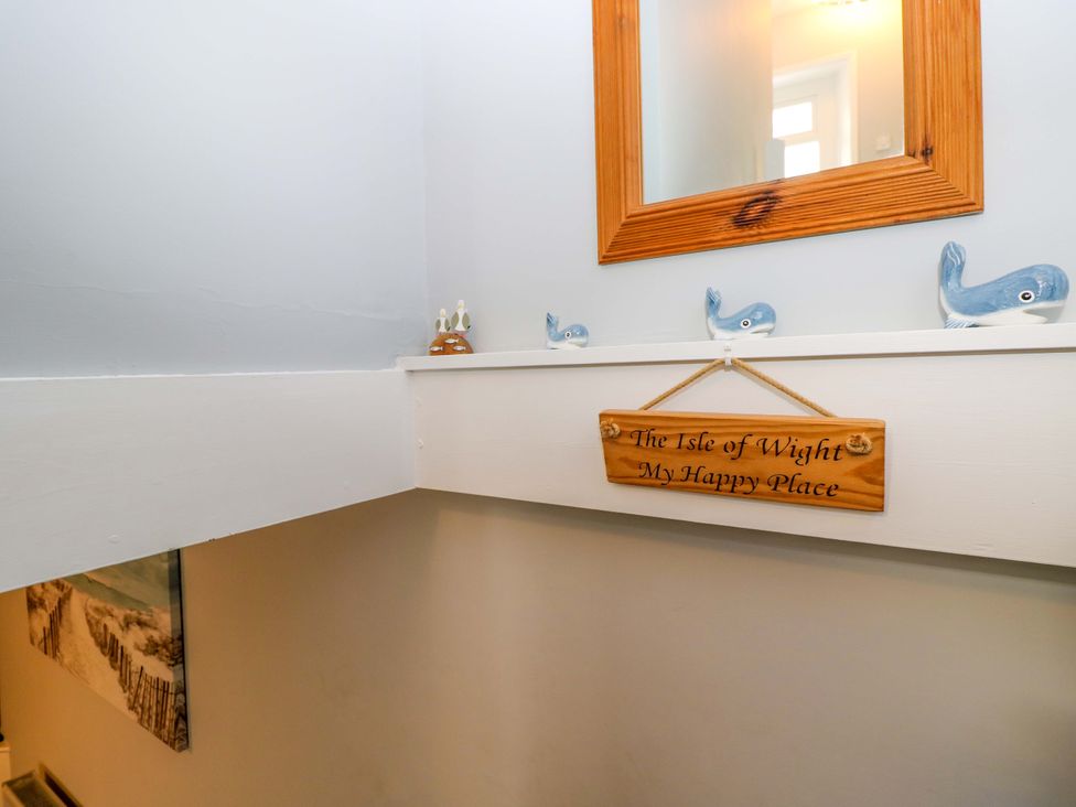 A stairway with a mirror and decorative items at Willow Cottage in Ventnor