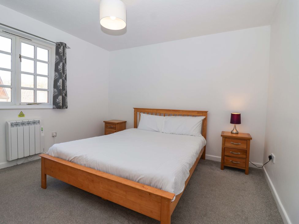 A bedroom with a bed and bedside table at Bracken Cottage in St Tudy