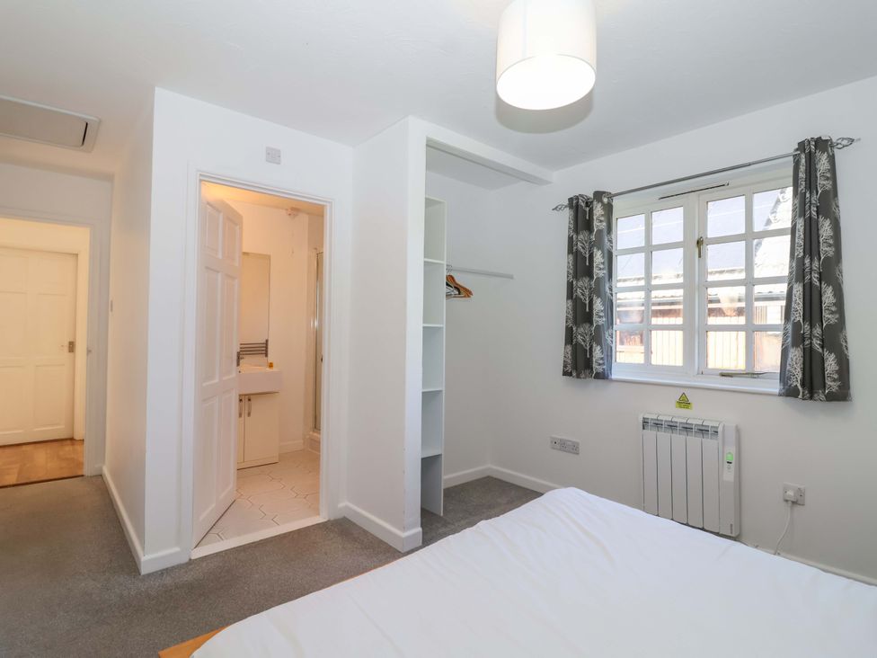 A bedroom with a bed and wardrobe at Bracken Cottage St Tudy